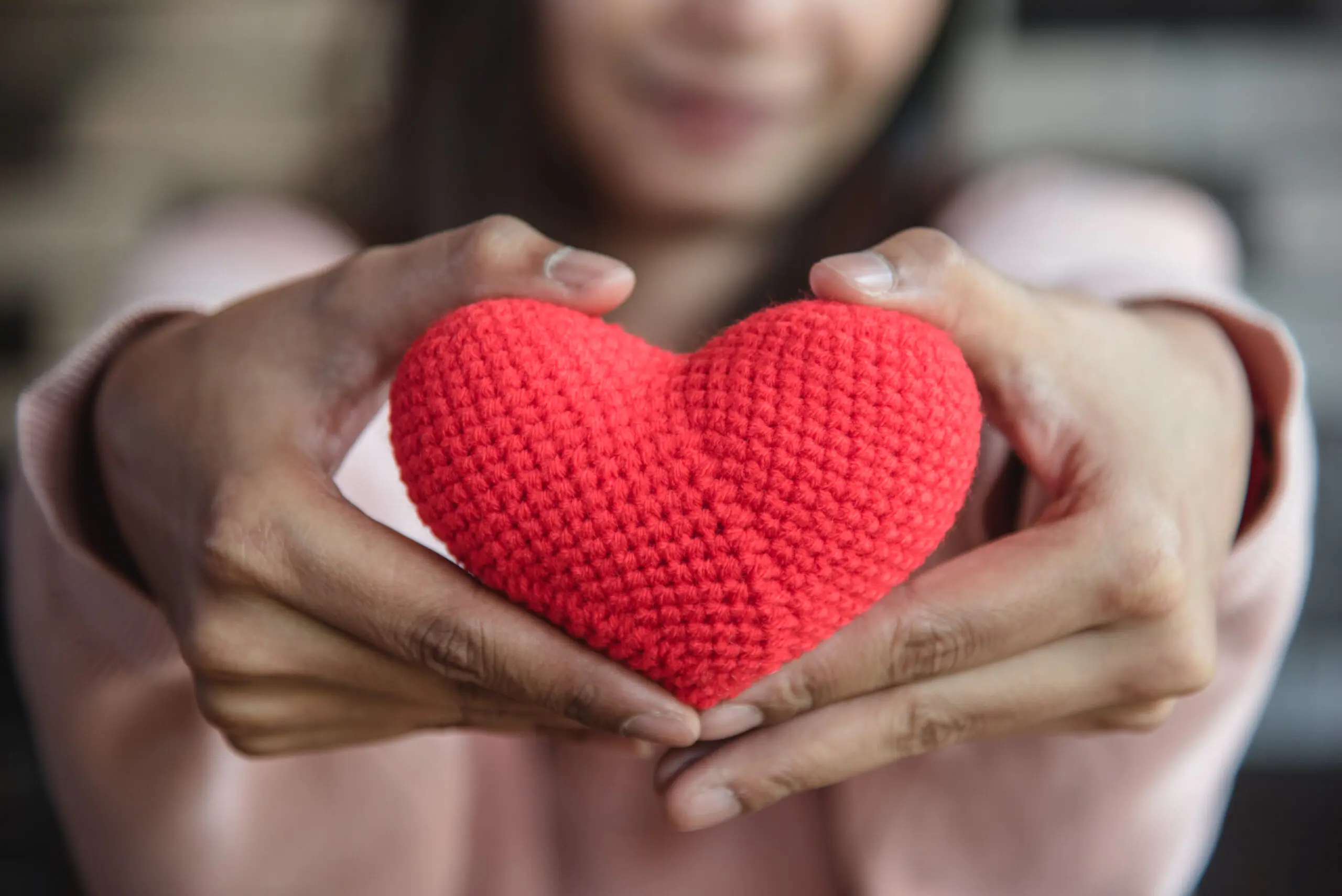 big-red-yarn-heart-holding-giving-front-by-woman-hand-scaled